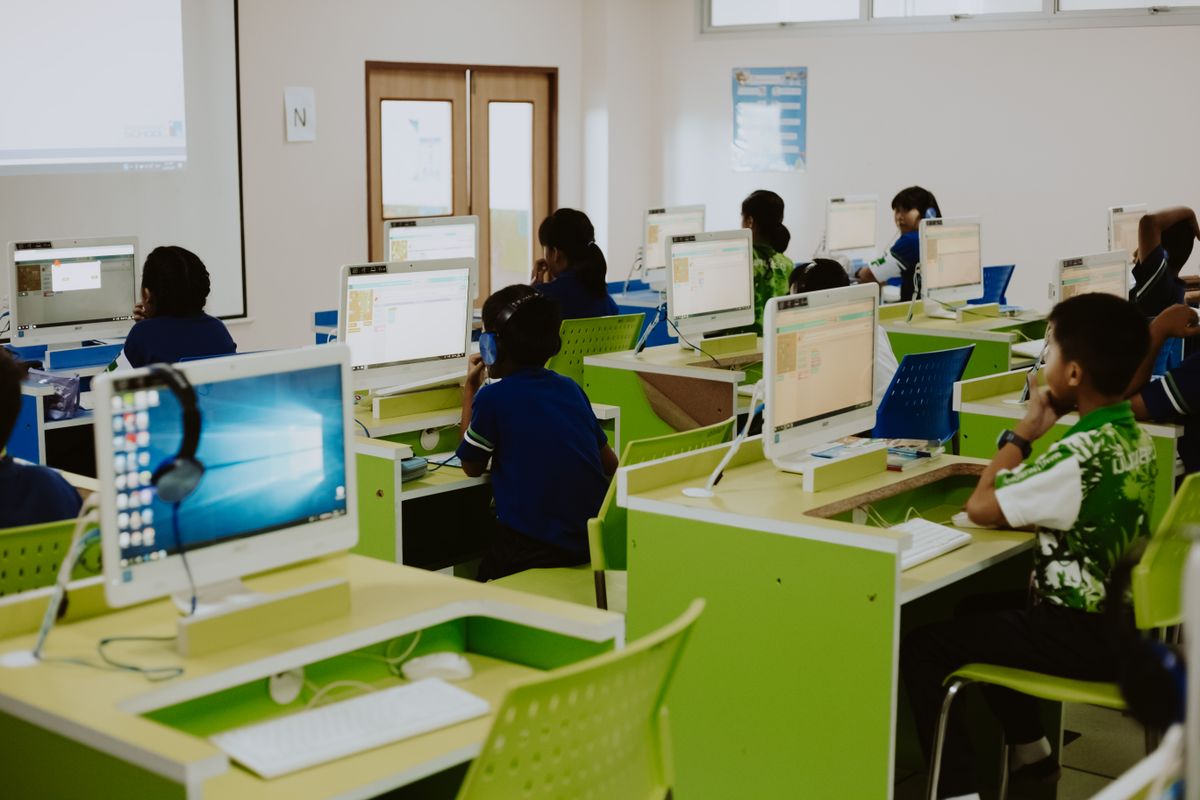 A dimly lit office with desks and monitors at dusk