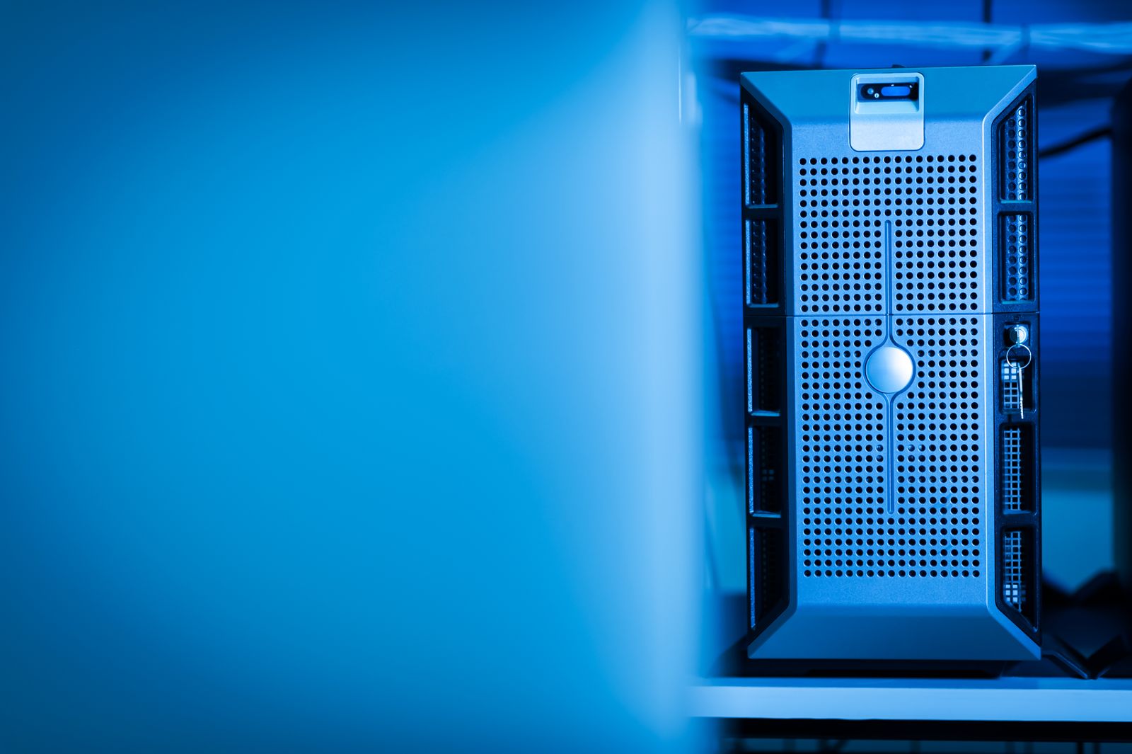 A single server tower lit in blue inside a data center rack