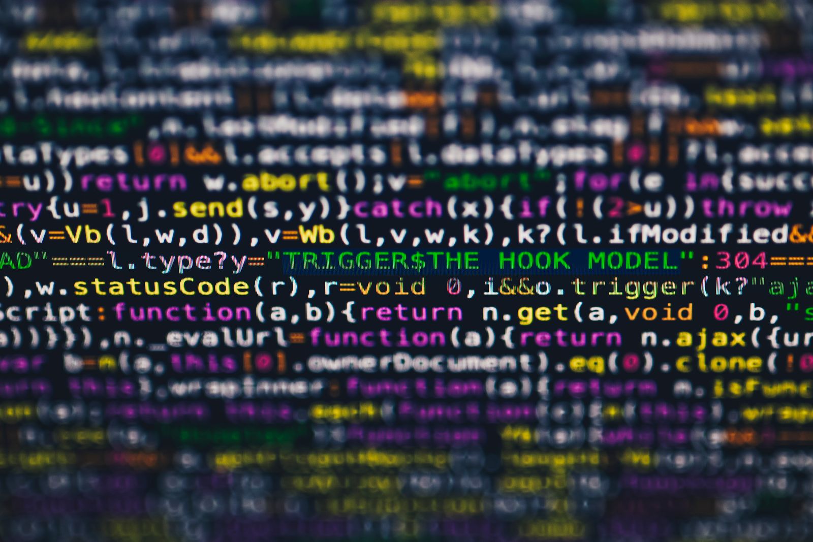 Colorful JavaScript source code glowing on a dark screen