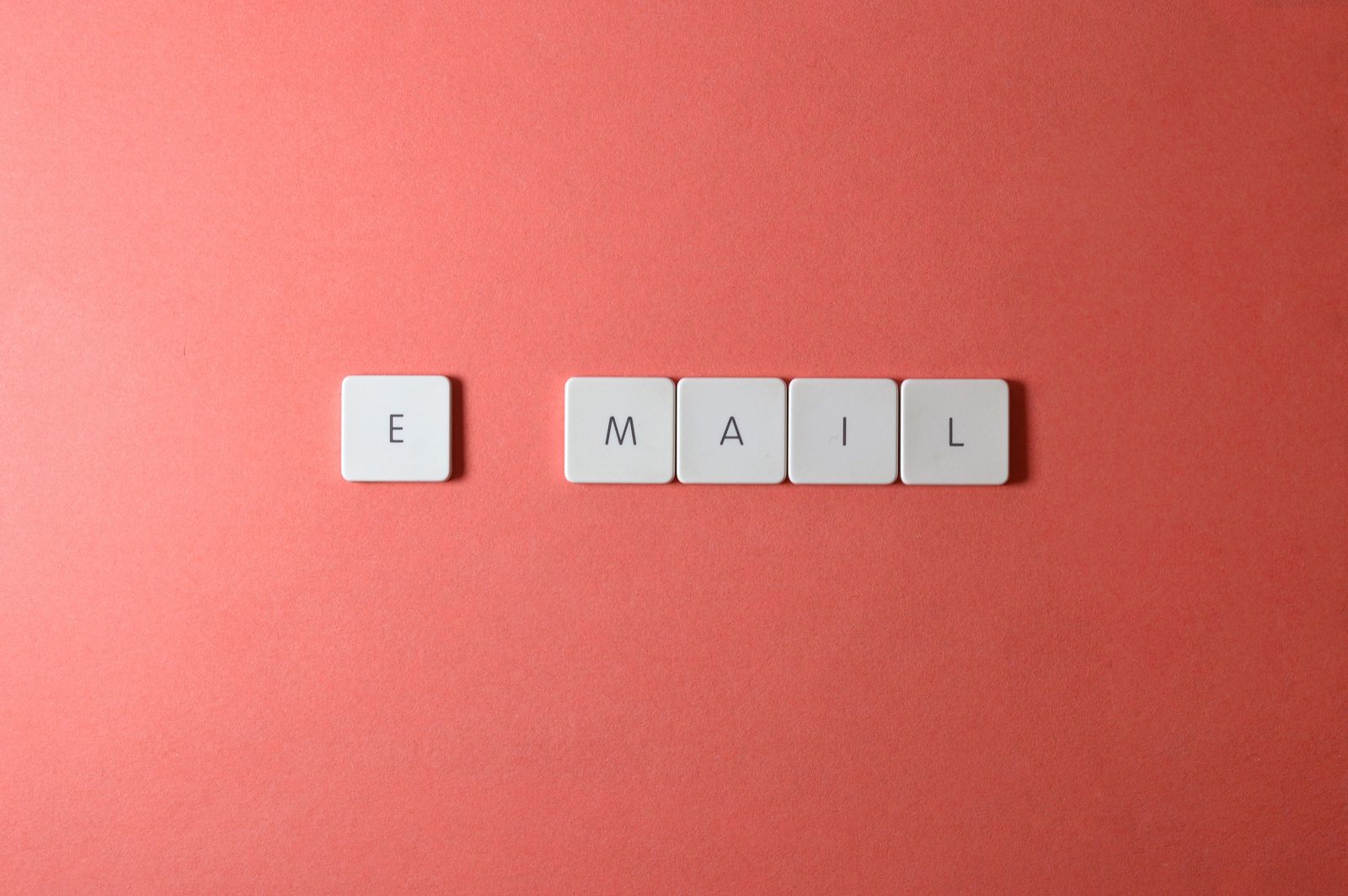 Keyboard keys spelling out the word email on a coral red background