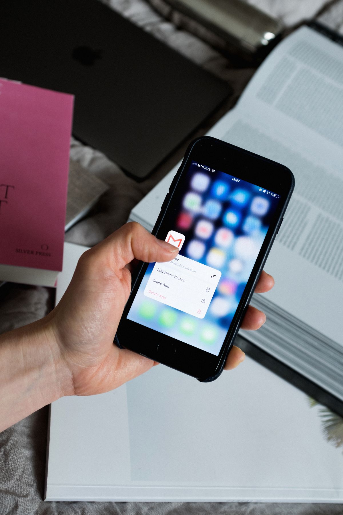 A hand holding a phone about to open a mail app