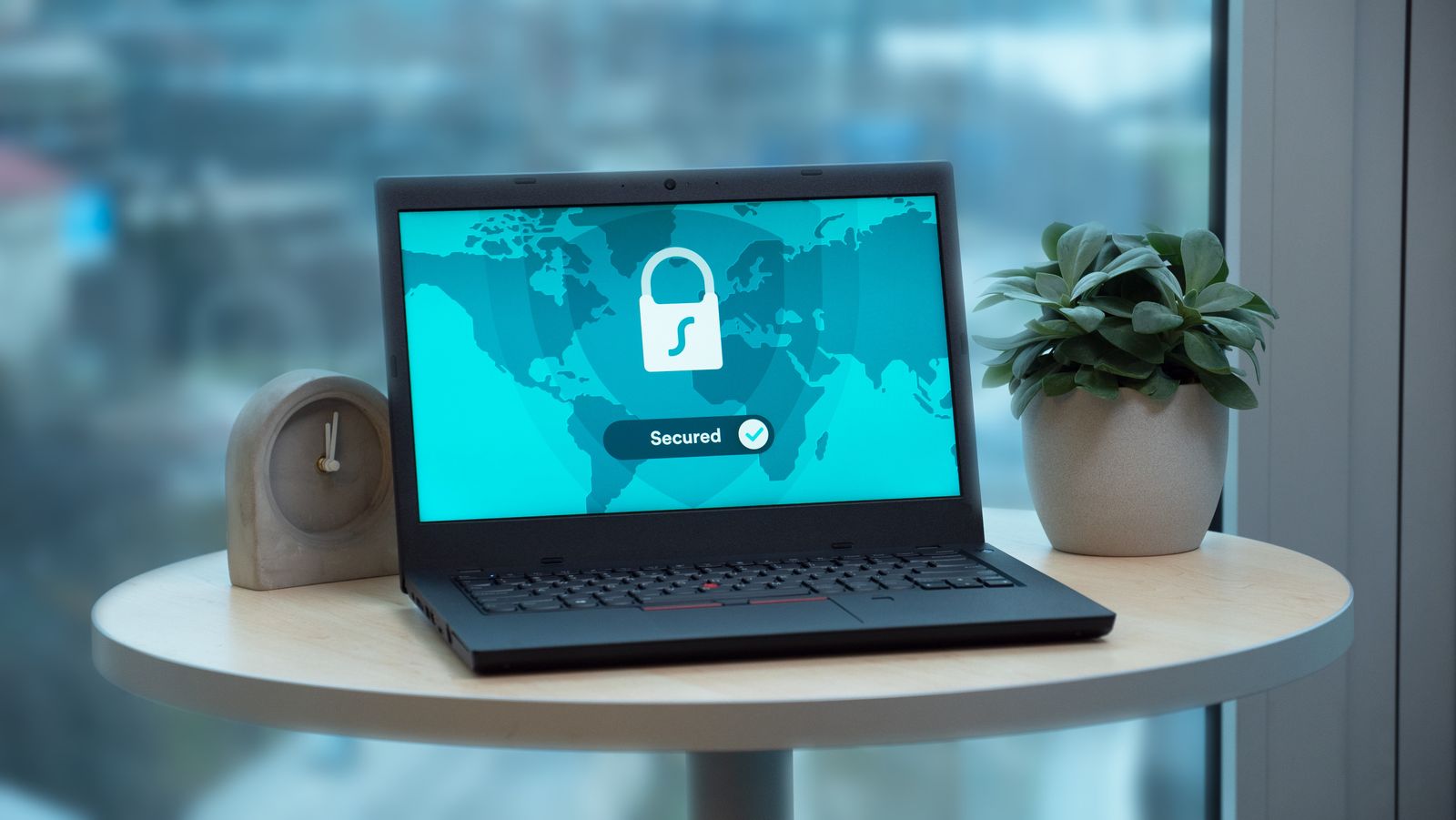 A laptop on a round table showing a secured padlock screen
