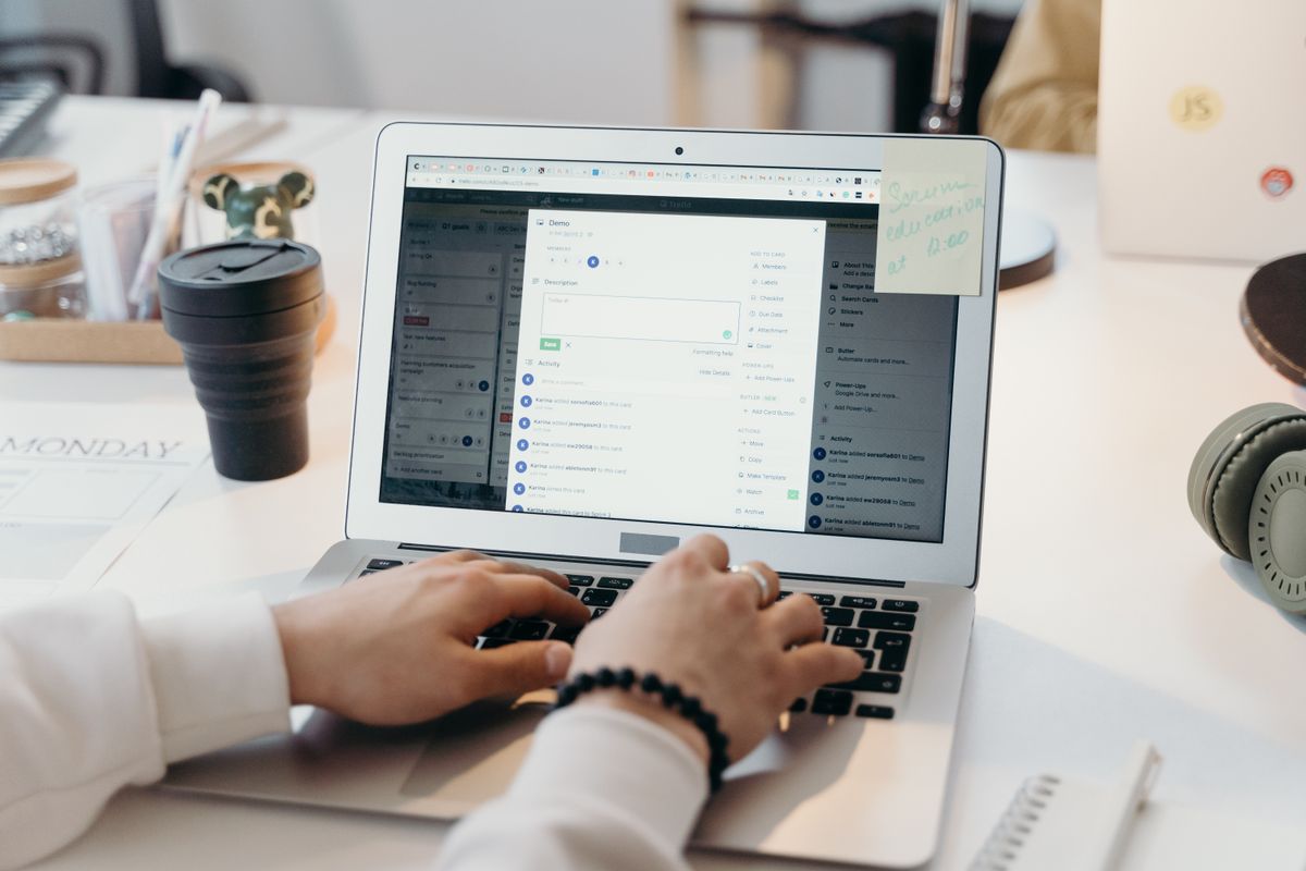 Hands typing on a laptop showing a crowded email inbox
